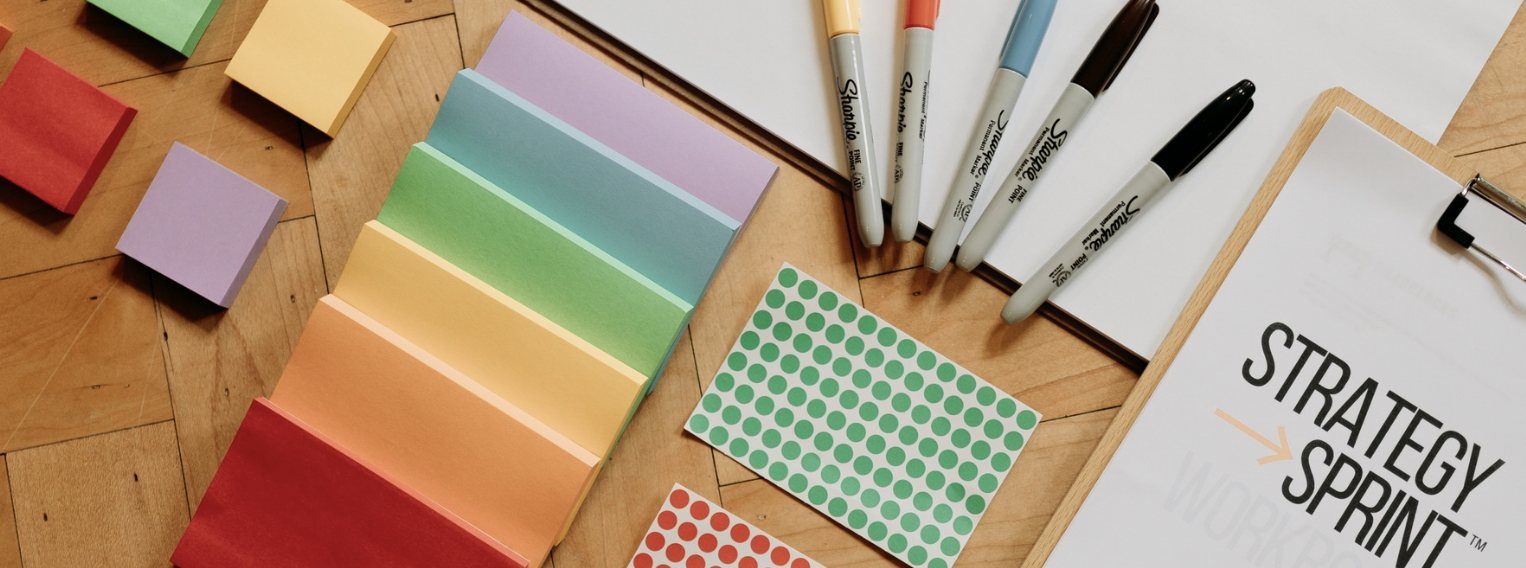 Post-its, stiften, stickers en het Strategy Sprint™-werkboek op tafel